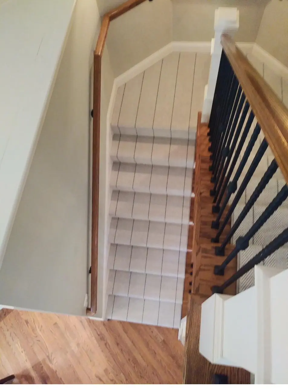Plush neutral carpet — white-spindle stairs, installed by QFI